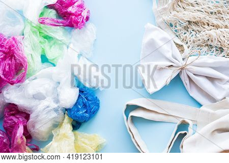 Many Disposable Plastic Bags Vs Reusable Cotton Bags On A Blue Background. Zero Waste Shopping. Sust