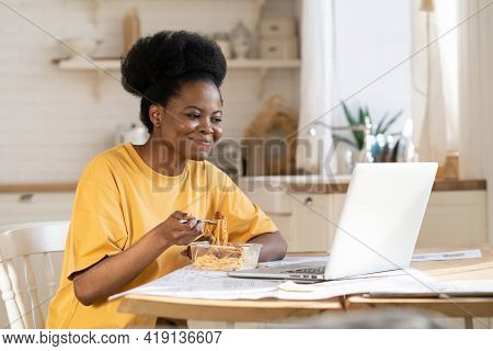 African Girl Eat And Watch Funny Video, Film On Laptop, Webinar For Study Or Make Conference Call To