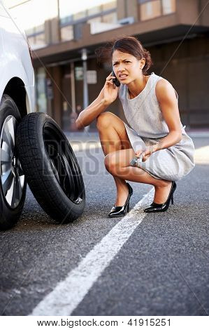 Femme, appeler le service après-vente avec un pneu crevé sur la voiture dans la ville