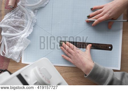 Top View Of Female Hands Are Drawing Design Of A New Collection Of Lingerie. Workplace Of A Professi