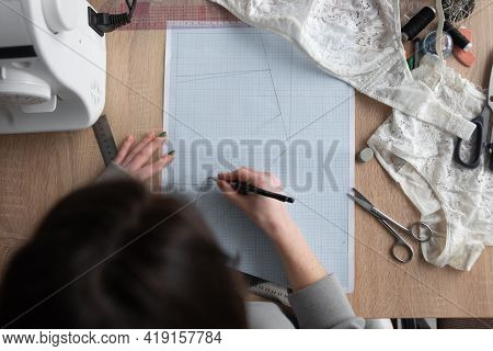 Top View Of Female Hands Are Drawing Design Of A New Collection Of Lingerie. Workplace Of A Professi