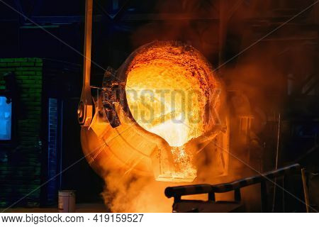 Metal Casting Process In Foundry, Molten Iron Pours From Ladle To Blast Furnace.