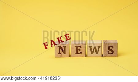 Wooden Cubes With The Inscription False News On A Yellow Background. The Concept Of Information Hygi