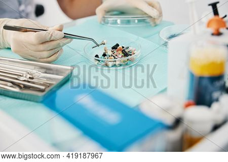 Person Picking Prophy Brush With Medical Tweezers
