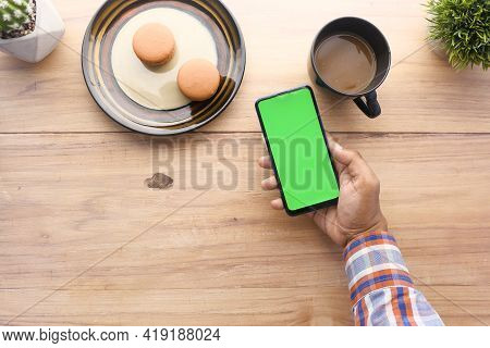 Top View Of Man Hand Using Smart Phone On Office Desk