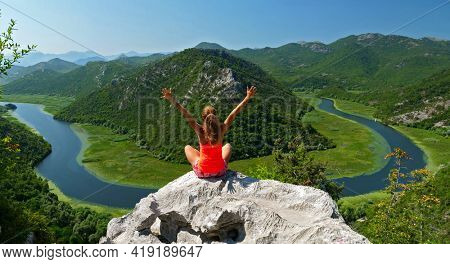 wman enjoying beautiful view of river and mountain