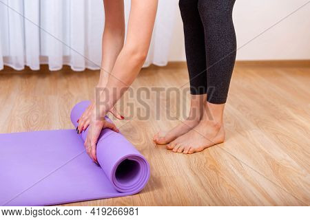 Girl Is Exercising On Floor Mat In Morning Sunshine At Home. Close Up Of A Womans Hands Is Rolling U