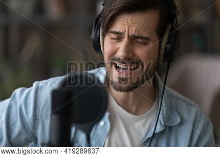 Close Up Man Singer In Headphones Singing, Using Professional Microphone