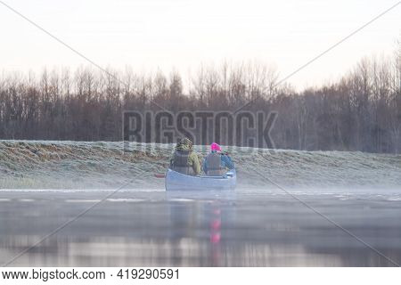 Man Rowing A Canoe In Early Spring In The Early Morning. Lifestyle. Morning Landscape, Fog By The Mo