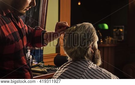 Hipster Client Getting Haircut. Barber With Scissors And Client. Guy With Long Dyed Blond Hair Close