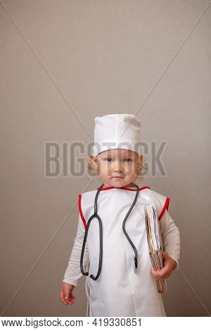 Cute Happy Little Girl Stands On White Background In Doctor Costume With Stethoscope Stethoscope Aro