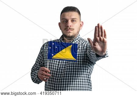 White Guy Holding A Flag Of Tokelau And With A Serious Face Shows A Hand Stop Sign Isolated On A Whi