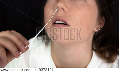 Young Woman Taking A Covid-19 Sars-cov-2 Test During Corona Pandemic On Dark Black Background, Quick