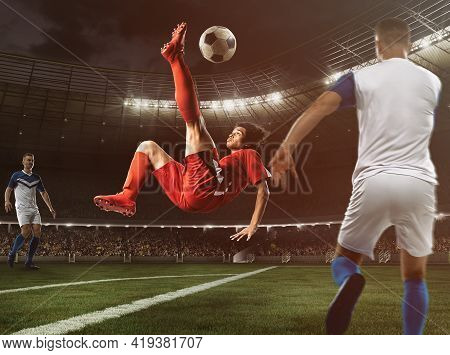 Soccer Striker In Red Uniform Hits The Ball With An Acrobatic Kick In The Air At The Stadium