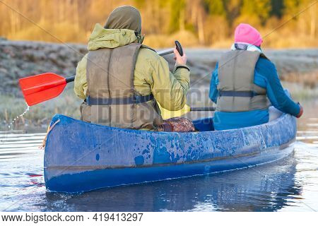 Retirees Rowing A Canoe In Early Spring In The Early Morning. Seniors Lifestyle. Morning Landscape, 