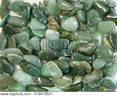 Macroshooting Of Natural Mineral Rock Specimen - Tumbled Green Aventurine Gemstone Isolated On White