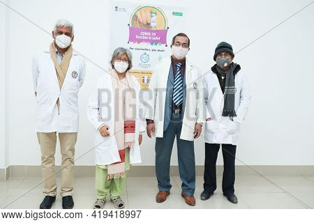January 2021, Kishanganj, India. A Team Of Senior Doctors Standing Near A Wall Poster Of Covid 19 Va