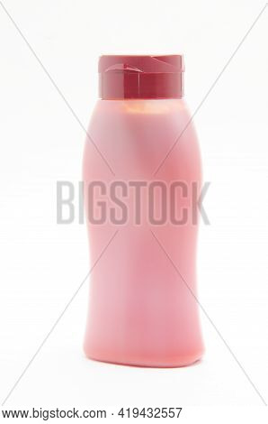 White Bottle With Red Food Product On White Background