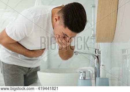 Man Suffering From Nausea Near Sink In Bathroom. Food Poisoning