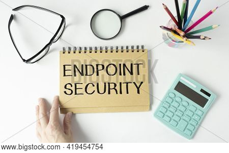 Text Endpoint Security On Yellow Paper Next To Financial Reports, Calculator And Gold Pensils.