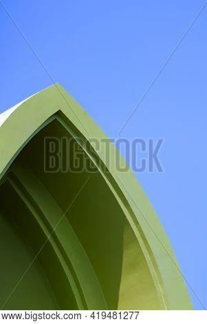 Low Angle View Of Vintage Green Gable Roof In Curved Triangle Shape Against Blue Sky Background In V