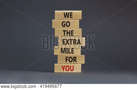 Go The Extra Mile Symbol. Wooden Blocks With Words 'we Go The Extra Mile For You'. Beautiful Grey Ba