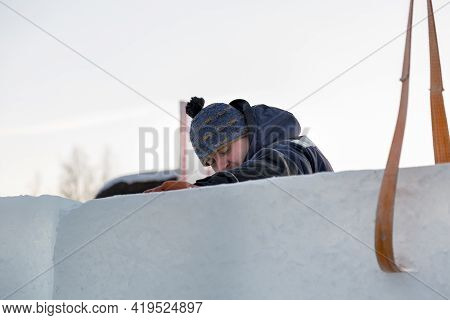 Slinger In A Blue Jacket Unloading Ice Blocks