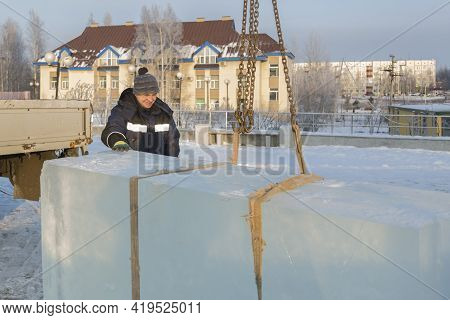 Slinger In A Blue Jacket Unloading Ice Blocks
