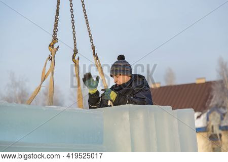 Slinger In A Blue Jacket Unloading Ice Blocks