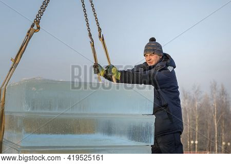 Slinger In A Blue Jacket Unloading Ice Blocks
