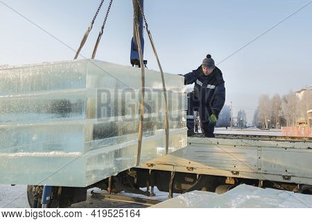 Slinger In A Blue Jacket Unloading Ice Blocks