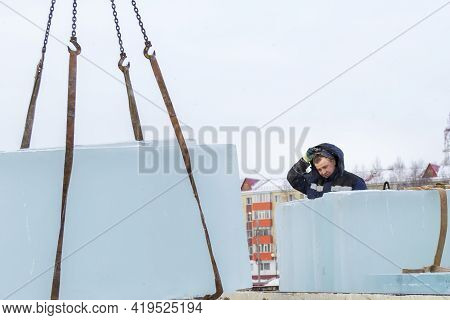 Slinger In A Blue Jacket Unloading Ice Blocks
