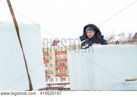 Slinger In A Blue Jacket Unloading Ice Blocks