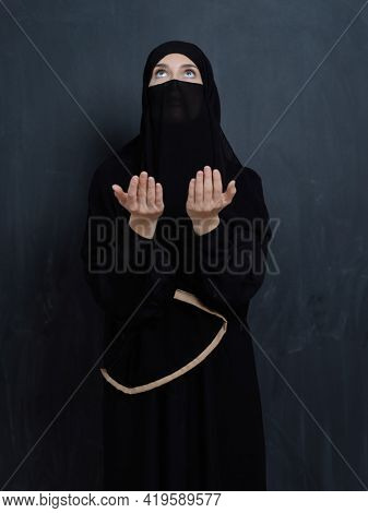 Portrait of young Muslim woman with niqab making dua