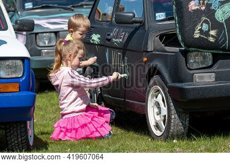 Daugmale, Latvia - May 01, 2021: Children Draw With Crayons On A Vintage Car Fiat 126