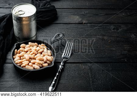 White Canned Kidney Beans Set, With Metal Can, In Cast Iron Frying Pan, On Black Wooden Table Backgr