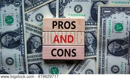 Pros And Cons Symbol. Wooden Blocks With Words 'pros And Cons'. Beautiful Background From Dollar Bil