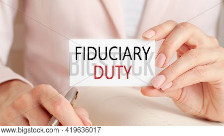 A Paper Card In The Hand Of A Woman With The Inscription Fiduciary Duty