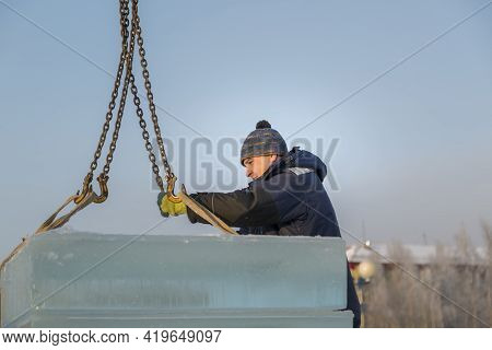 Fitter In A Blue Jacket Works With A Chain Metal Sling