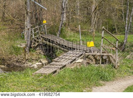 Improvised Ramshackle Wooden Self-made Bridge Over A Rivulet In Sunny Ambiance