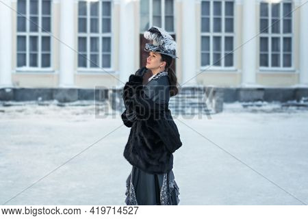 A Woman Dressed As A 19th-century Noblewoman Stands Outside The Castle.winter In Russia