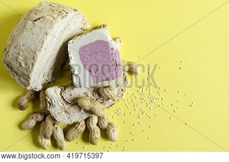 Peanut And Sesame Halva With Decoration In The Form Of Peanuts And Sesame Seeds On A Yellow Backgrou
