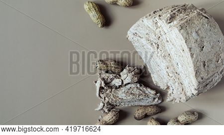 Peanut Halva And Peanut Nuts On A Light Brown Background Top View Of Kopi Space. Halva Oriental Swee