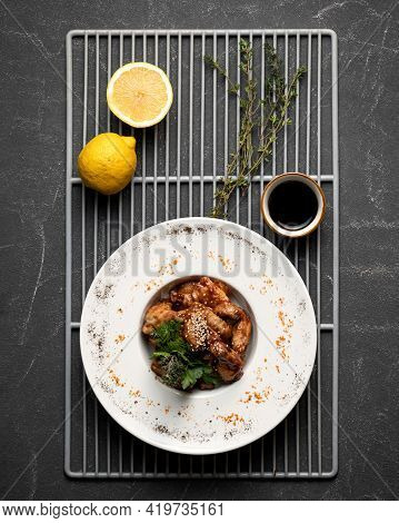 Grilled Chicken Wings With Lemon And Rosemary. Hearty Lunch, Cooked Poultry. Top View On Black Backg