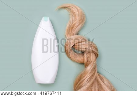 Shampoo Or Conditioner Bottle And Blonde Hair Lock Tied In Knot. Strand Of Honey Blonde Hair, Top Vi