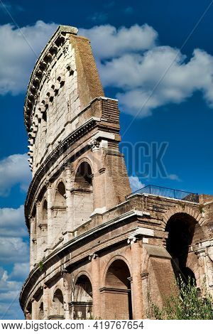 Rome, Italy. Arches Archictecture Of Colosseum (colosseo) Exterior With Blue Sky Background And Clou