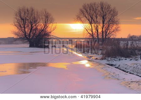 Winterliche Auen mit Reed und Banken gegen wolkenschleier Sonnenuntergang-Himmel