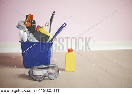 Blue Bucket Full Of Cleaning And Redecoration Tools And Substances With Goggles