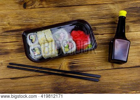 Uramaki Sushi Rolls With Surimi In Plastic Box On Wooden Table. Top View. Sushi For Take Away Or Del