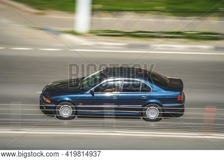 Old Blue Bmw E39 On The City Road. Fast Moving Car On The Street. Vehicle Driving Along The Street I